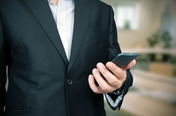 Affärsman med smart telefon i office — Stockfoto