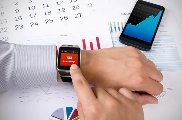 Hombre trabajando con reloj inteligente en la oficina —  Fotos de Stock