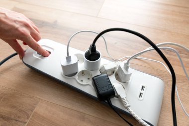 Kişi güç bandına bir cihaz takıyor. Şarj aleti tutan adam..