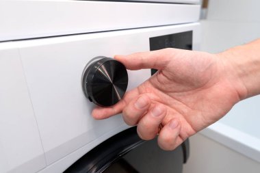 Bir çamaşır odasında beyaz çamaşır makinesi. Ev işleri konsepti