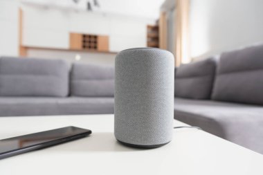 Oturma odasında akıllı bir hoparlör. Akıllı ev sisteminde akıllı asistan.