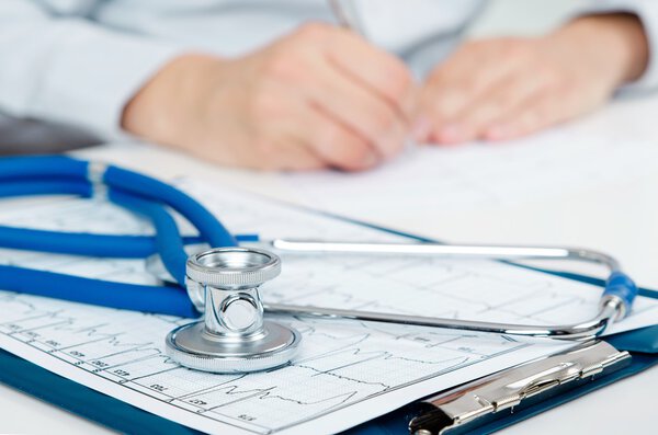 Medical doctor working at desk. Close up of stethoscope