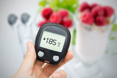Diyabet Glikoz seviyesi testi yapıyor. Meyve arka planda
