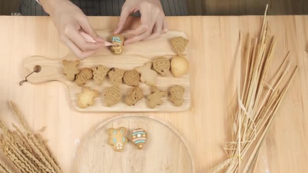 Chef Schreibt Zuckercreme Auf Selbst Gebackene Lebkuchen Schneemannplätzchen Und Legt — Stockvideo