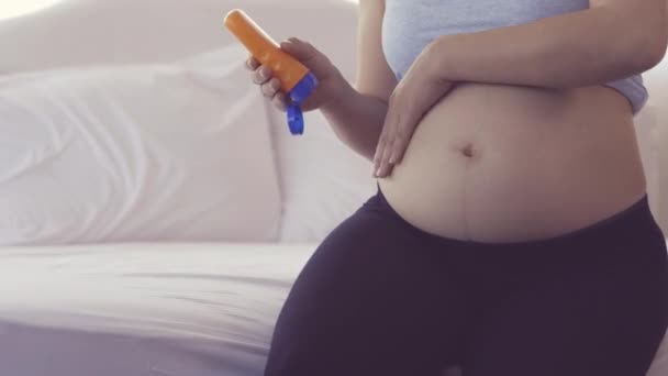 Genç Asyalı Hamile Anne Losyon Şişesi Tutuyor Yatakta Otururken Karnına — Stok video