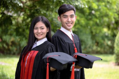 Bekar kıyafeti giyen ve kırmızı püsküllü şapka takan iki Asya üniversiteli.