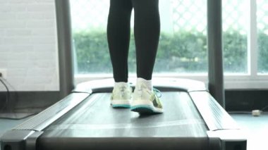 Close up Foot Fitness Asian woman walk  warm up on treadmill machine by rear view camera, marathon races training at fitness gym