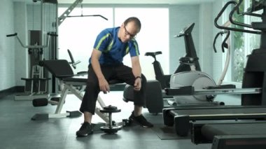 Genç Asyalı adam dambılla vida sıkın ve spor salonunda yedek kulübede oturarak Dumbbell Curl egzersizi yapın. spor, vücut geliştirme, spor ve insan konsepti