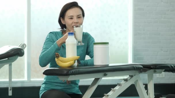Young Asian Woman Sportswear Sitting Drinking Milk Weight Training Gym — Stock Video