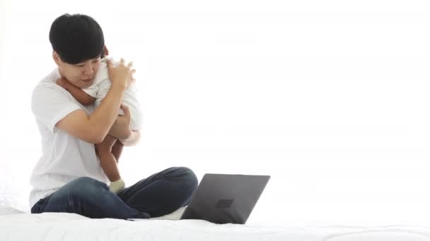 아시아 여성의 아기가 온라인 쇼핑을 배경으로 침실에서 복제품을 확인하고 — 비디오