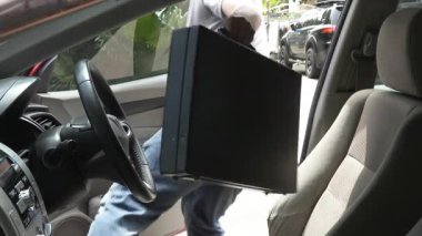 Maskeli hırsız korkmuş sürücünün çantasını çalmak için arabanın camına uzanıyor. Araba soygunu, hırsızlık, tehlike, kentsel suç ve kişisel güvenlik kavramı