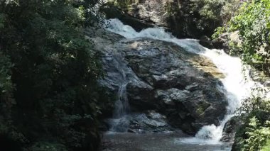 Bereketli ormanlarla çevrili kayaların üzerinden akan tropikal şelalenin geniş manzarası el değmemiş vahşi doğa, sükunet ve eko-turizm güzelliğini gözler önüne seriyor.