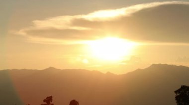 Sıcak alevler ve parlayan gökyüzü ile dağ sırtı üzerinde parlayan parlak altın gün batımı, barış, ilham ve seyahat için doğal güzelliği sembolize eder.