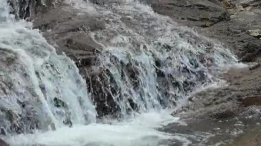 Yumuşak beyaz köpük ve doğal dokularla kaplı katmanlı kayaların üzerinden akan küçük şelale. Spa geçmişi, sağlık kavramları, doğa terapisi ve çevre tasarım projeleri için mükemmel.