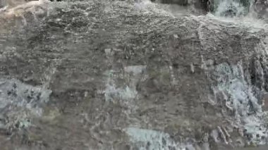 Arka planda bambu bulunan doğal taş basamakların üzerinden akan küçük şelale kırsal eko-yaşam tarzını, doğal su akışını ve sürdürülebilir çevreyi sergiliyor.