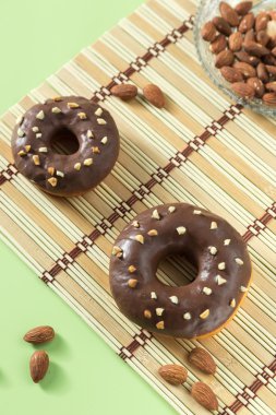 Badem ile ahşap bir tahta üzerinde iki lezzetli çikolatalı çörekler