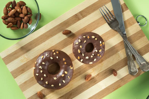 Donuts saborosos em uma placa de madeira com amêndoas — Fotografia de Stock