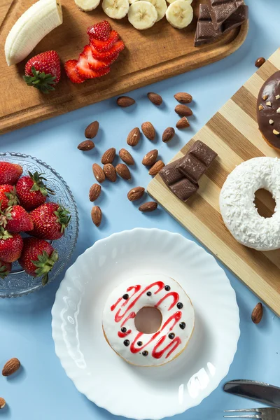 Tasty donuts with fruit and nuts — Stock Photo, Image
