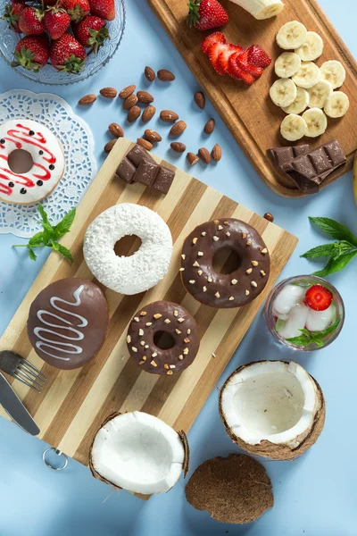 Tasty donuts with fruit and nuts on the table — Stock Photo, Image