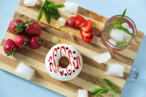 Tasty donut with strawberry and lemonade on the table — Stock Photo, Image