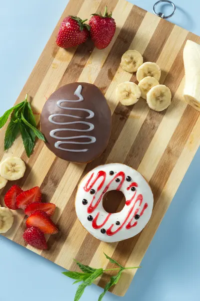 Two tasty donuts with fruit and strawberry on the table — Stock Photo, Image