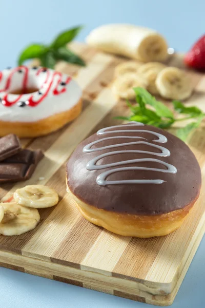 Two tasty donuts with fruit and strawberry on the table — Stock Photo, Image