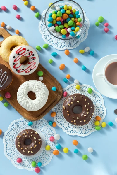 Tasty donuts with fruit and candy on the table — Stock Photo, Image