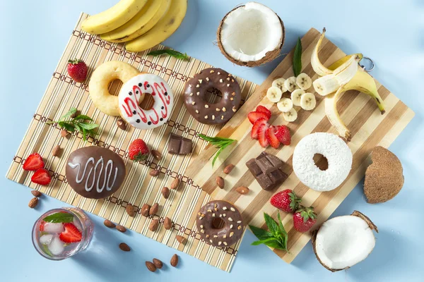 Tasty donuts with fruit and nuts on the table — Stock Photo, Image