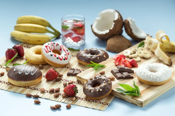 Tasty donuts with fruit and nuts on the table — Stock Photo, Image