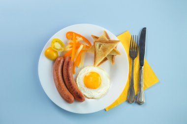 Nefis bir kahvaltı. Tereyağı, portakal suyu, reçel, bal, kruvasan, bıçak, çatal ile servis edilir. Sarı, mavi. Mavi arkaplan.