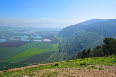 Gilboa Dağı 'ndan Jezreel Vadisi (Megiddo Vadisi) manzaralı manzara. Toprak sürme, renkli tarlalar, balık havuzları. İsrail 'de Aşağı Celile Bölgesi