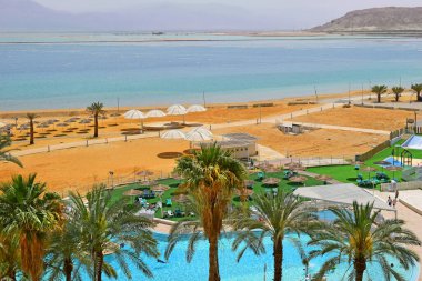 Ein Bokek tatil beldesindeki boş halk plajında çok az tatilci vardı. Ölü Deniz, İsrail, covid 19 salgını sırasında.