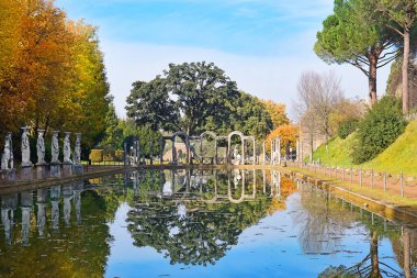 Villa Adrian (Hadrian 's Villa)' daki Yunan heykelleri ve İtalya 'nın Tivoli kentindeki sudaki yansımalarla çevrili Canopus adlı antik havuz.