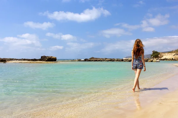 Ung flicka går på stranden — Stockfoto