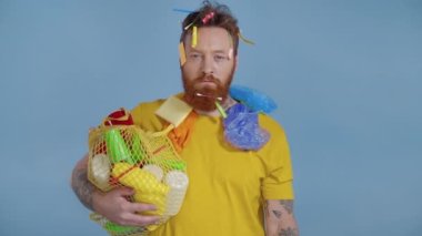 Elinde plastik çöp olan ve şişe sıkan bir adam. Yavaş çekim.