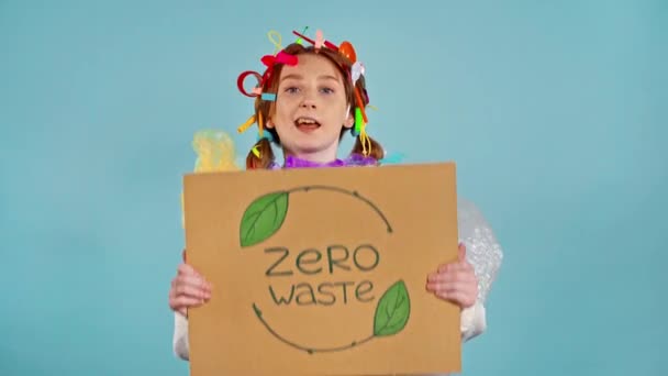 贴着塑料垃圾的女孩拿着标语牌写着 零浪费 看着摄像机 — 图库视频影像