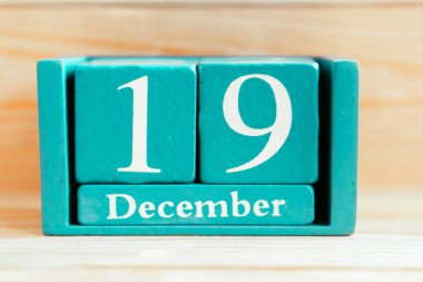 19 Aralık. Ahşap zemin üzerinde ay ve tarih olan mavi küp takvimi.
