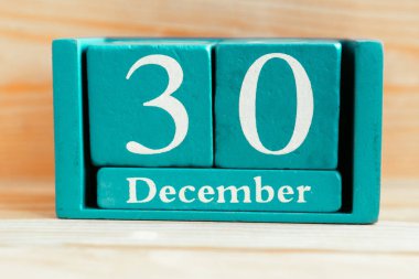 30 Aralık. Ahşap zemin üzerinde ay ve tarih olan mavi küp takvimi.