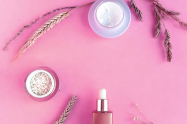 Pembe pastel arka planda doğal kozmetik ürünleri, metin için kopyalama alanı