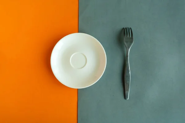 Κενό Πιάτο Και Πιρούνι Γκρι Και Πορτοκαλί Φόντο Αντιγραφή Χώρου — Φωτογραφία Αρχείου