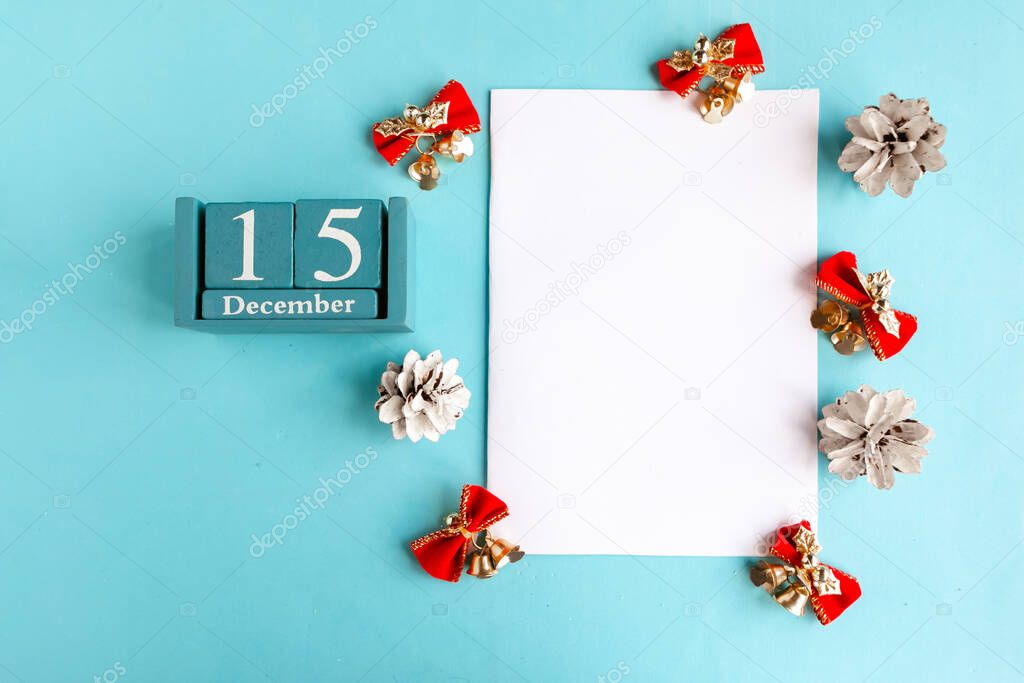 December 15. Blue cube calendar with month and date and white mockup blank on blue background.