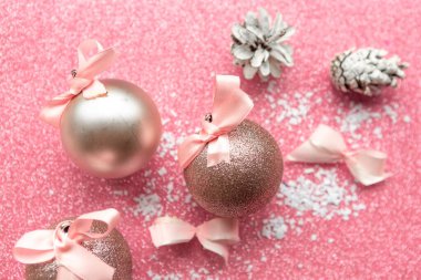 Pembe pırıltılı arka planda noel takıları, Mutlu noeller ve mutlu yeni yıllar