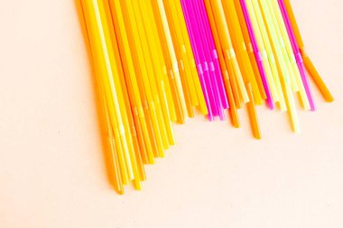 Pembe arka planda çok renkli plastik kokteyl pipetleri, üst manzara. Kokteyl yap.. 