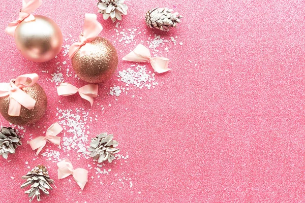 Christmas baubles on pink glitter background, Merry Christmas and Happy New Year. Copy space for the text