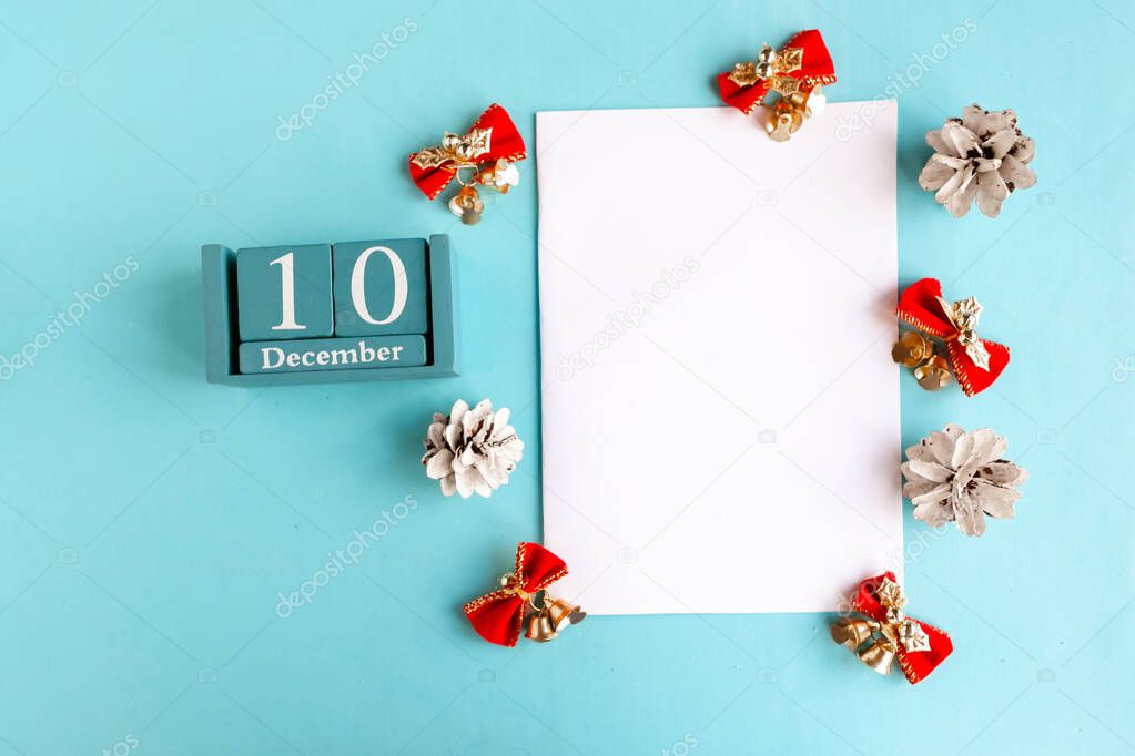 December 10. Blue cube calendar with month and date and white mockup blank on blue background.
