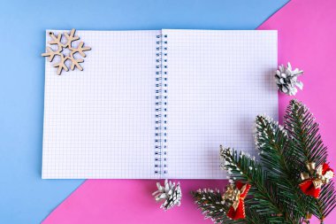 Renkli arka planda model defterleri ve Noel ağacı dallarını aç. Yeni yıl tebrik kartı şablonu. Mutlu Noeller ve mutlu yıllar.