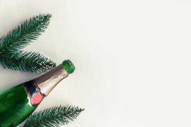 Şampanya şişesi ve noel ağacı dalları arka planda, üst görünümde, boşluğu kopyala