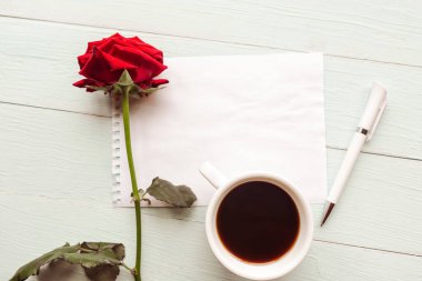 Kahve fincanı, gül ve maket masası boş.