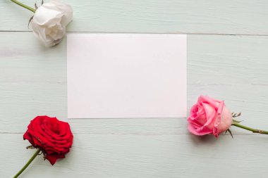 Tahta arka planda üç gül ve beyaz model, metin için kopyalama alanı