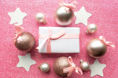 Hediye kutusu ve pembe parıltılı arka planda takılar, üst manzara. Mutlu Noeller ve mutlu yıllar. Noel tebrik kartı.